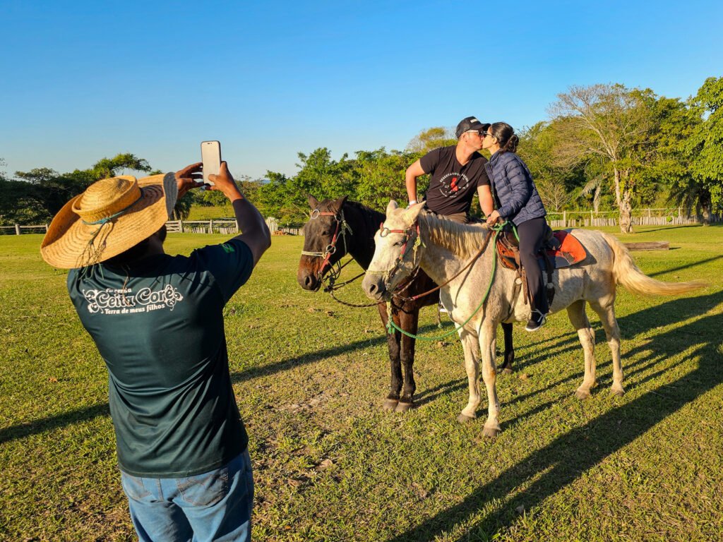 Guia fazendo foto de casal no passeio a cavalo.