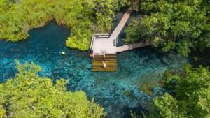 Descubra a diferença entre flutuação e cachoeira. Pessoas relaxando em um lago azul.