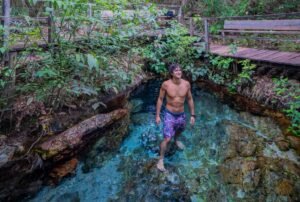 Homem aproveitando a água cristalina de Bonito nas férias de julho.