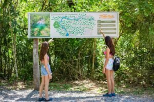 Meninas olhando mapa de cachoeiras do passeio da Fazenda Ceita Corê